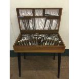 A teak and walnut Viners cutlery table containing a Viners stainless steel cutlery set