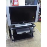 A JVC 32" LCD TV on stand with remote together with a Toshiba DVD player and remote and a TV stand