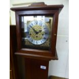 A mahogany cased granddaughter clock with key.