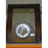 An Edwardian oak framed mirror together with an oak cased mantel clock with pendulum and key.