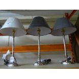 Three contemporary chrome table lamps.