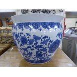 A large oriental blue and white fish bowl /planter and flower decorations.