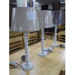 A set of three wooden table lamps with shades