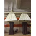 A pair of stitched leather table lamps with shades