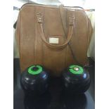 A leather bowls bag with a set of bowls and a leather holdall