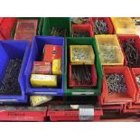 A crate of plastic organising drawers with a metal rack of nails, screws, nuts,