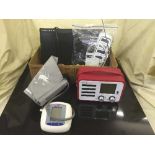 A box of DVD player and remote, radio, BP monitor,