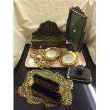 A decorative photo frame, brass glove box, brushes on stand,