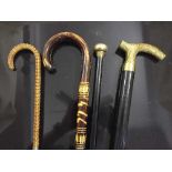 A large quantity of walking sticks including silver topped walking cane, hip flask walking stick,
