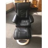 A black leather relaxer armchair and stool