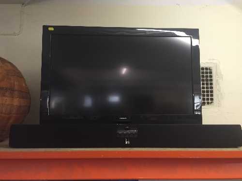 A Bush 32 inch LCD TV with remote and a Roth sound bar with remote