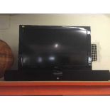 A Bush 32 inch LCD TV with remote and a Roth sound bar with remote