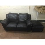 A black leather two seater settee with footstool