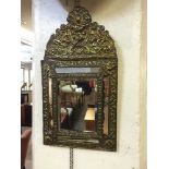 An early 20th century brass framed cushion mirror