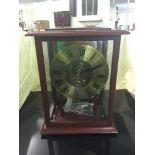 A brass skeleton clock with pendulum and key in glazed mahogany case