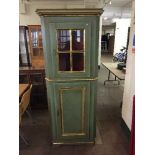 A green and gilt painted glazed door corner cabinet