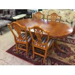 A reproduction yew wood dining table with leaf and four shield back chairs