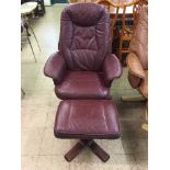 A maroon leather swivel armchair with stool