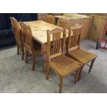 A rectangular pine dining table and six rail back chairs