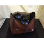 A leather bowls bag and four bowling bowls