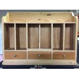 A pine wall rack fitted three drawers