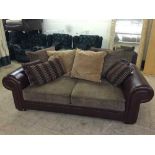 A brown leather and fabric two seater settee with scatter cushions