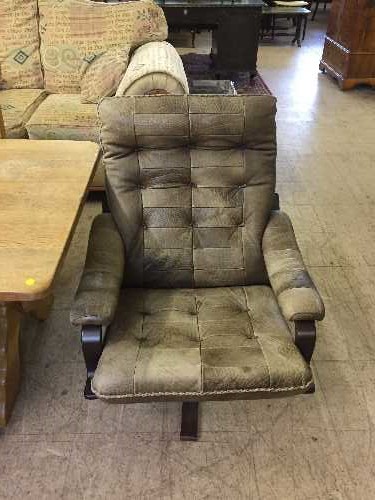 A late 20th century stained beech framed swivel leather armchair