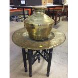 A brass spitoon and a brass topped table