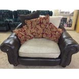 A brown leather and fabric "cuddle" chair with scatter cushions