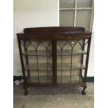 A mahogany double door display cabinet on claw and ball feet