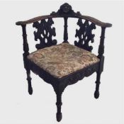 A nineteenth century carved oak corner chair with tapestry seat, width 68 cm.