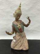 A Lladro bisque figure of a kneeling Thai girl in traditional dress, height 45cm.