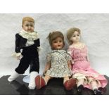 A nineteenth century wax headed doll, together with four further vintage dolls.