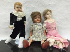 A nineteenth century wax headed doll, together with four further vintage dolls.