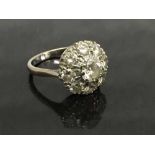 An early twentieth century 18ct white gold diamond cluster ring, size M.