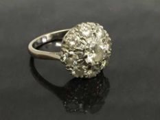 An early twentieth century 18ct white gold diamond cluster ring, size M.