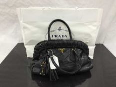 Prada : A lady's hand bag, soft black leather, with brass labelling, with leather fob and tassle,