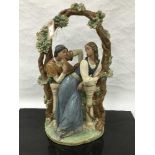 A Lladro bisque figure of a gentleman courting a lady beneath an arch, height 53cm.