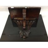 A mid nineteenth century mahogany wall bracket, the back carved with seven plumes ,
