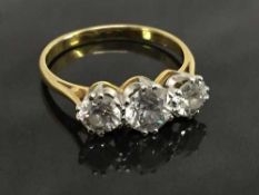 An 18ct gold three stone diamond ring, approximately 1ct, size M/N.