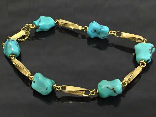 A yellow gold bracelet set with turquoise stones.