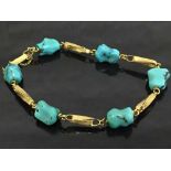 A yellow gold bracelet set with turquoise stones.