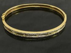An 18ct gold shaped bangle, set with parallel rows of diamonds, diameter 6 cm x 5 cm, 19.7g.
