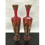 A pair of late Victorian Bohemian ruby glass vases, hand gilded and painted with floral decoration,