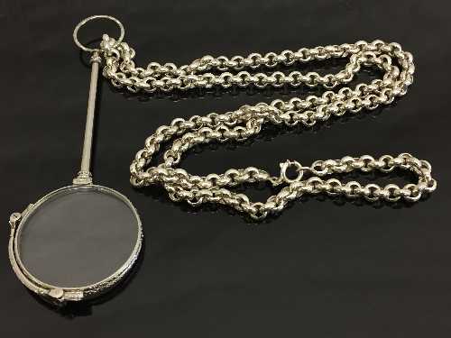 A white metal lorgnette suspended upon a Sterling silver belcher chain.