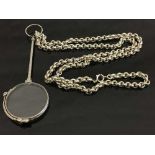 A white metal lorgnette suspended upon a Sterling silver belcher chain.