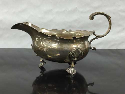 A George II silver sauce boat, London 1748, raised on three feet with lobed rim, height 9cm, 135.6g.