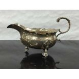 A George II silver sauce boat, London 1748, raised on three feet with lobed rim, height 9cm, 135.6g.