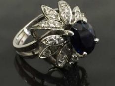 A mid twentieth century sapphire and diamond cluster ring, the sapphire approximately 1.