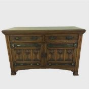 An Arts and Crafts carved oak sideboard, width 153 cm.